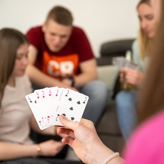 Junge Erwachsene spielen Karten