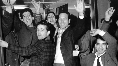Eine Gruppe der ersten 86 italienischen Gastarbeiter winkt während eines Aufenthalts auf dem Hauptbahnhof in Hannover aus dem Zug. 