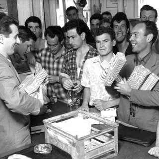 Eine Gruppe italienischer Gastarbeiter 1962 in Wolfsburg beim Kauf von Spaghetti.