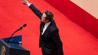 Elon Musk grüßt die Menge bei einer Indoor-Parade zur Amtseinführung von Präsident Trump.