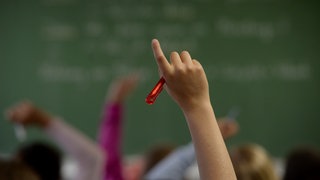 Schulkind meldet sich im Klassenzimmer