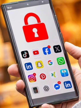 Schülerin mit Handy, auf dem die Social Media Apps mit einem Schloss  gesperrt sind