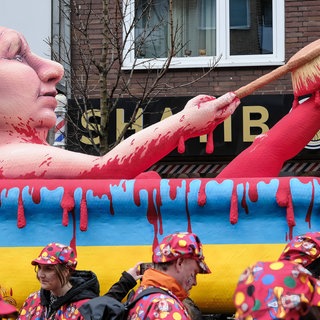 Auf dem Mottowagen liegt Putin in einer Badewanne voller Blut und schrubbt sich damit die Beine.