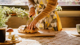 Eine Frau schneidet Brot