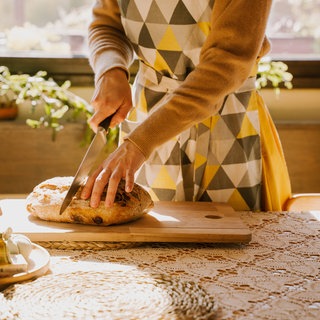 Eine Frau schneidet Brot