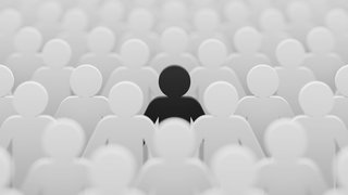 Schwarze Figur inmitten von weißen Figuren