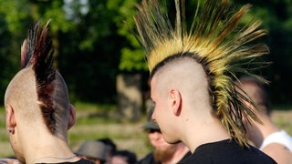 Zwei Punker hören ein Konzert. 
