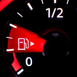 Die Nadel einer Tankanzeige in einem VW Passat zeigt wenig Kraftstoff an.