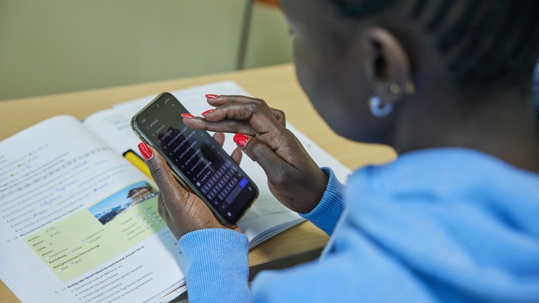 In einem Integrationskurs in der Hartnack-Schule werden Aufgaben über WhatsApp an die Schüler verschickt. 
