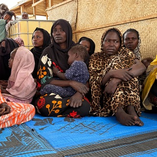 Flüchtlinge aus dem Sudan warten in der tschadischen Grenzstadt Adré auf dem Gelände des Roten Kreuzes auf den Weitertransport in ein Flüchtlingslager.