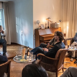 Eine Gastgeberfamilie veranstaltet einen Kulturabend im Wohnzimmer. Symbolfoto.