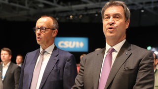 CSU-Parteitag 2022: Friedrich Merz (links) und Markus Söder singen gemeinsam die Nationalhymne