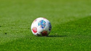 Ein Fußball liegt auf dem Rasen im Stadion