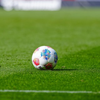 Ein Fußball liegt auf dem Rasen im Stadion
