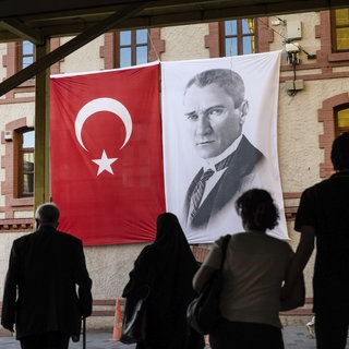 Die türkische Flagge wird neben einem Porträt von Mustafa Kemal Atatürk, dem Gründer der Türkischen Republik und ersten Präsidenten, gezeigt. 