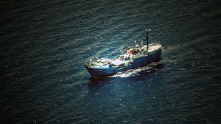 Das Rettungsschiff Iuventa aus Vogelperspektive im Meer treibend