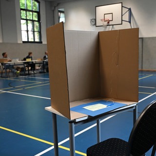 Leere Wahlkabine aus Pappe in einer Turnhalle