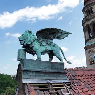 Eine Löwenfigur auf einem Kirchendach