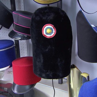 Verschiedene Hüte hängen an einer Wand