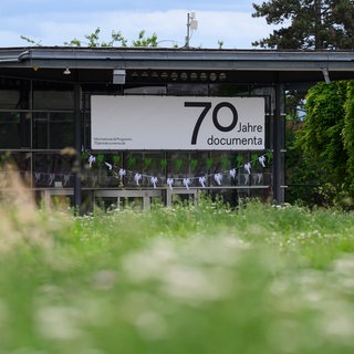 Eine Wimpelkette mit Palmen-Silhouetten hängt im Eingangsbereich der documenta-Halle.