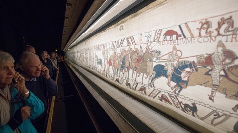 Ausstellungsbesucherinnen vor einem Wandteppich