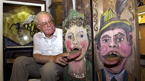 Der damalige Leiter des Bienenkundemuseums im Münstertal, Karl Pfefferle sitzt neben etwa mehr als 220 Jahre alten, so genannten Kamin-Bienenstöcken aus der Steiermark, bei denen sich der Einflug über der herausgestreckten Zunge befindet.