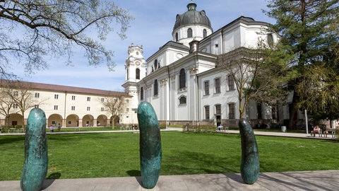 Essiggurken-Skulpturen in einer Reihe in einem Park aufgestellt.