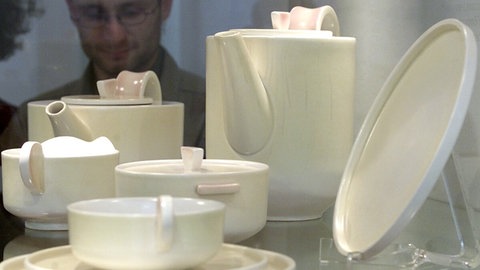 Weißes, schlichtes Kaffeeservice in einer Ausstellungsvitrine.