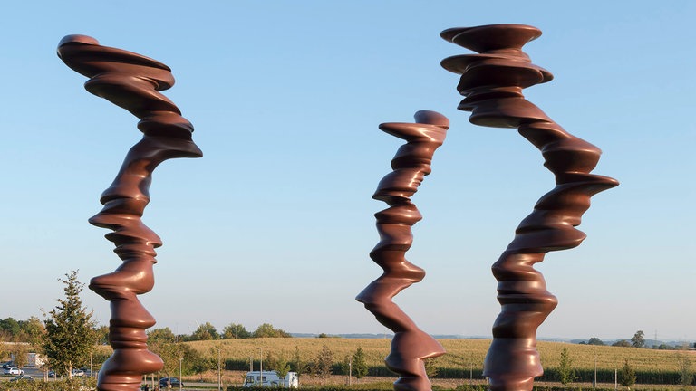 In sich gedrehte Säulen aus aufeinandergelgten Steingebilden im Skulpturengarten Würth.