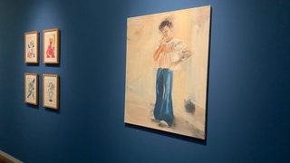 Figur in weißem Oberteil und Schlaghose vor weißer Wand