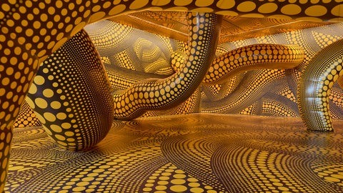 Inversive Skulptur von der Künstlerin Yayoi Kusama mit gelben Tentakelarmen, die schwarz gepunktet sind. 
