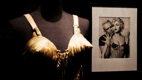 Der von Madonna (links) getragene Gaultier-Kegel-BH neben einem Bild von Madonna und dem französischen Modedesigner Jean Paul Gaultier