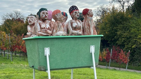 Die „Winzer Wellness“ von Otto Beer, zeigt Menschen beim gemeinsamen Wannenbad in einem Weinzuber