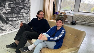 Zwei Künstler sitzen auf einem Sofa