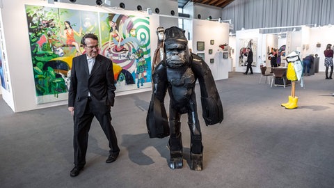 Besucher betrachtet Gorilla-Statue. Art Karlsruhe 2020.