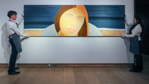 Mitarbeitende von Christie's in London mit dem Gemälde "Kym 2, 1989-90" von Axel Katz