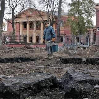 Nach einem nächtlichen russischen Raketenangriff steht ein älterer Mann vor dem Krater einer Rakete auf der Straße vor dem Nationalen Kunstmuseum. 