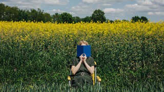 Lesenswert Magazin 03.08.2025, Frau mit Buch in der Natur