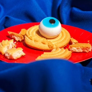 Gruseliges Spielzeugauge auf einem süßen Gebäckstück.