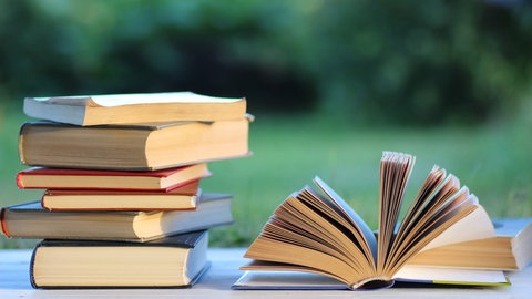 Ein Buchstapel draußen im Garten