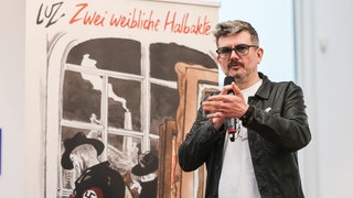 Der Comiczeichner Luz vor dem Cover seines neuen Werkes