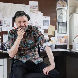 Ralf König, Comicautor und Zeichner, sitzt in seinem Atelier. 