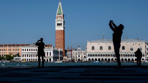 Touristen-Silhouetten in Venedig vor dem Campanile des Markusdoms und dem Dogenpalast