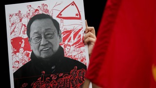 Eine Frau hält ein Poster von Jose Maria Canlas Sison, dem Gründer der kommunistischen Partei auf den Philippinen.