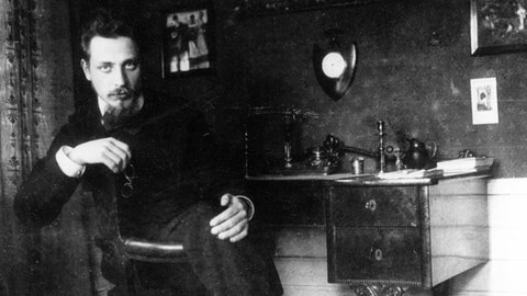 Der Dichter Rainer Maria Rilke sitzt in seinem Büro