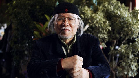 Der japanische Comic-Zeichner Leiji Matsumoto posiert vor einer Begrünung beim Comicfestival in Angoulême 2013
