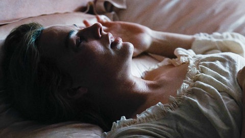 Margot Robbie liegt nachdenklich im Bett