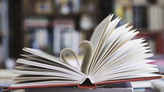 Ein Buch, dessen Seiten als Herz geformt sind.