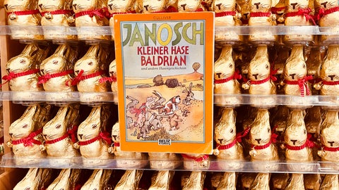 Das Buch "Kleiner Hase Baldrian" von Janosch vor einem Lindt Goldhasen Regal