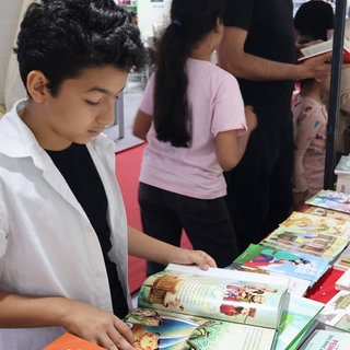 Ein Junge liest ein Buch am Chinesischen Pavillon der 40. Internationalen Buchmesse in Tunis